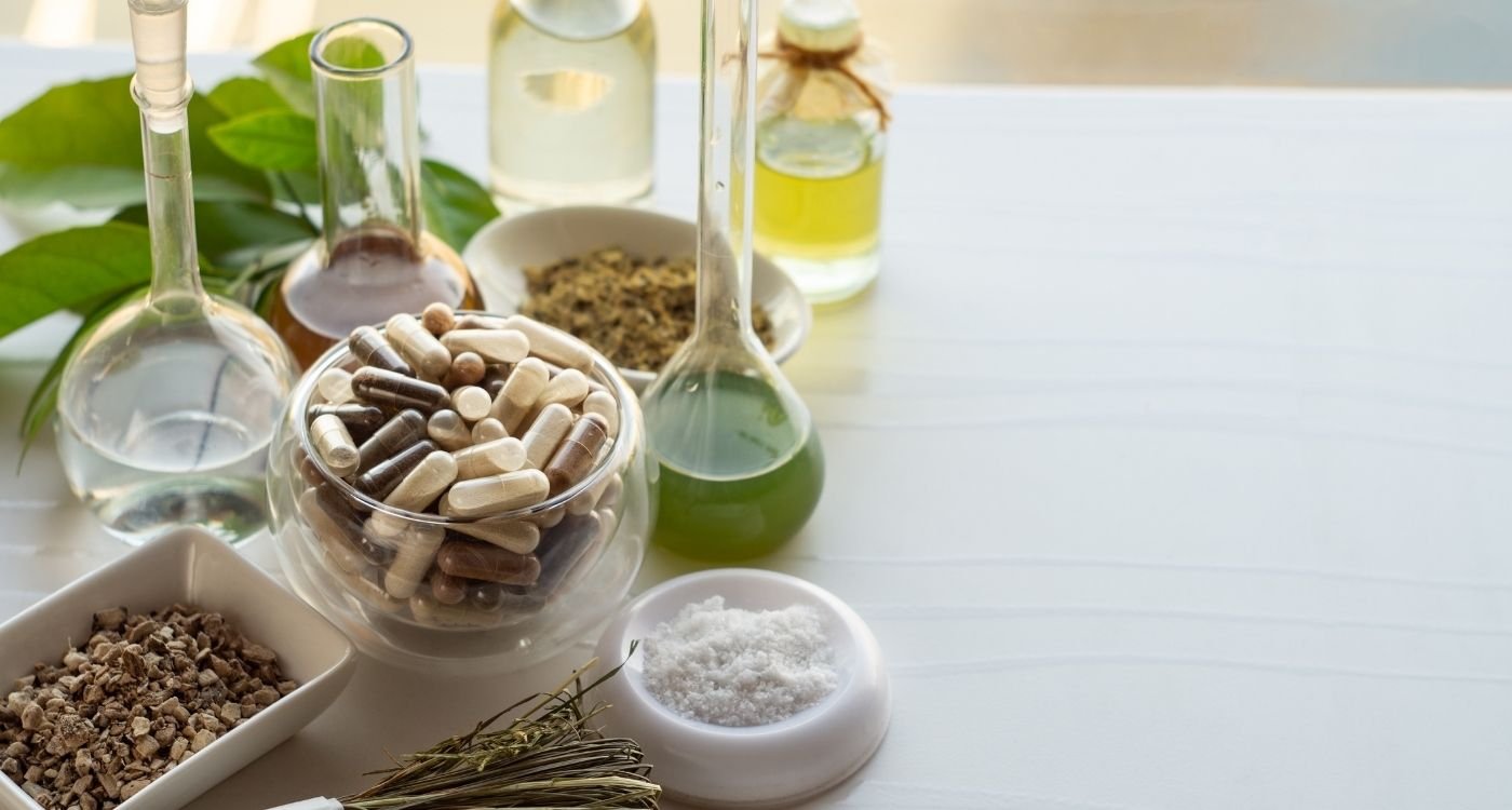 Suplementos naturais ao lado de extratos vegetais e frascos de laboratório, simbolizando o uso consciente do boro na menopausa para saúde óssea e hormonal.