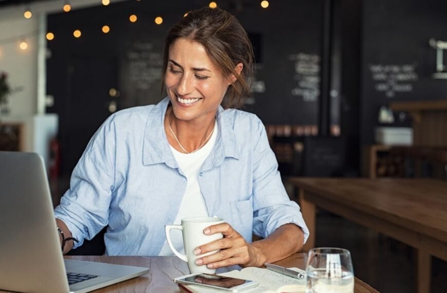Mulher madura trabalhando com confiança e leveza, representando bem-estar durante a menopausa no trabalho.
