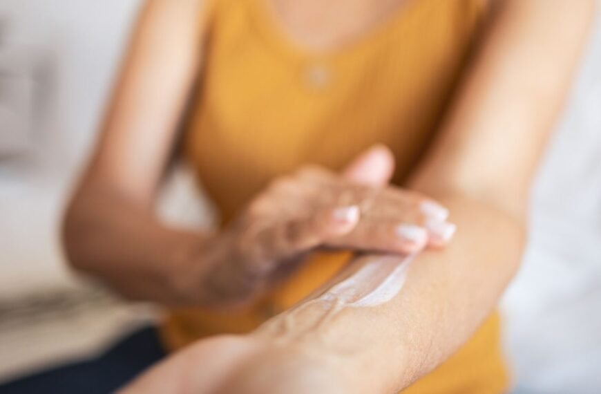 Imagem desfocada de uma mulher passando um creme de reposição hormonal demonstrando que a terapia de reposição hormonal na menopausa não é mais um vilão na vida da mulher.