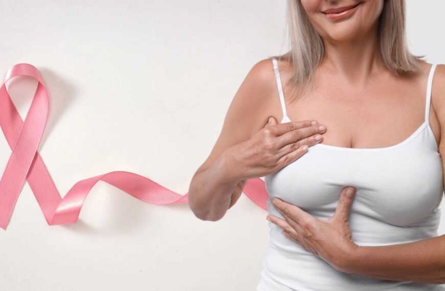 Mulher 50+ observa o próprio corpo com atenção e serenidade, reforçando o cuidado com a saúde das mamas na menopausa.